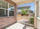 Cozy porch view with brick detail, wooden railing, and a glimpse of the backyard at 4816 S Elk Way, Aurora, CO 80016