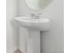 Bathroom with pedestal sink, a round mirror, and neutral walls at 10580 Waco St, Commerce City, CO 80022