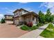 Charming two-story home boasts a well-manicured lawn, vibrant landscaping, and inviting front porch at 10580 Waco St, Commerce City, CO 80022