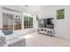 Bright living space features a plush sofa, large windows, and a modern entertainment center with television at 10580 Waco St, Commerce City, CO 80022