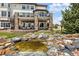 Backyard view of the patio, pond, and spiral staircase at 7724 Kryptonite Ln, Castle Rock, CO 80108