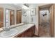 Bright bathroom with double sinks, wood cabinets, and a separate room with a shower over the toilet at 7724 Kryptonite Ln, Castle Rock, CO 80108