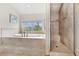 Bright bathroom with a soaking tub under a window and a separate glass-enclosed shower, creating a spa-like atmosphere at 7724 Kryptonite Ln, Castle Rock, CO 80108