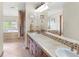 Bathroom featuring double sinks with tile countertops, wood cabinetry, and a separate tub and shower at 7724 Kryptonite Ln, Castle Rock, CO 80108