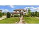 Stately home featuring manicured lawns, mature trees, and a terracotta roof at 7724 Kryptonite Ln, Castle Rock, CO 80108
