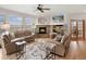 Cozy living room featuring a stone fireplace, hardwood floors, comfortable seating, and ample natural light at 7724 Kryptonite Ln, Castle Rock, CO 80108