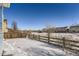 Snowy backyard with a wooden fence and open space at 7746 S Joplin Ct, Englewood, CO 80112