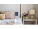Close up of bedding, decor, and a nightstand with a lamp and flowers in the main bedroom at 9071 E Phillips Dr, Centennial, CO 80112