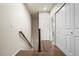 Upstairs hallway featuring a railing, and multiple closet doors at 9071 E Phillips Dr, Centennial, CO 80112