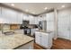 Open kitchen with granite countertops, stainless appliances, a center island, and ample white cabinet storage at 9071 E Phillips Dr, Centennial, CO 80112