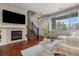 Bright living room with a cozy fireplace, stairs to upper level and a large window at 9071 E Phillips Dr, Centennial, CO 80112