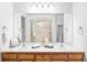 Bathroom featuring a dual sink vanity with wood cabinets and a large mirror reflecting the glass shower at 1415 N Washington St # 303, Denver, CO 80203