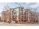 Exterior view of a multi-story brick apartment building with balconies and well-maintained landscaping at 1415 N Washington St # 303, Denver, CO 80203