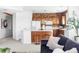 Open-concept kitchen with stainless steel appliances, center island with seating, and brick accent wall at 1415 N Washington St # 303, Denver, CO 80203