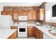 Well-lit kitchen featuring sleek white appliances, beautiful wood cabinets, and an eye-catching brick backsplash at 1415 N Washington St # 303, Denver, CO 80203