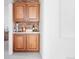 Charming wet bar area features wood cabinets, a white countertop, and a decorative brick backsplash at 1415 N Washington St # 303, Denver, CO 80203