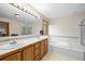 Large bathroom featuring double sinks, a jacuzzi tub, and glass door shower at 29825 Kennedy Gulch Rd, Conifer, CO 80433