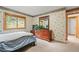 Cozy bedroom featuring a wooden dresser with mirror, complemented by neutral carpet and patterned wallpaper at 29825 Kennedy Gulch Rd, Conifer, CO 80433