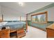 Relaxing bedroom featuring a canopy bed, large window, and carpet flooring at 29825 Kennedy Gulch Rd, Conifer, CO 80433
