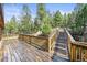 Spacious wooden deck features a staircase leading to a landscaped yard at 29825 Kennedy Gulch Rd, Conifer, CO 80433