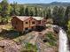 Attractive multi-level home with mature trees, landscaping, and a winding driveway in a serene forest setting at 29825 Kennedy Gulch Rd, Conifer, CO 80433