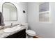 Stylish powder bathroom featuring granite countertop, modern sink, and decorative mirror at 11722 W Belmont Pl, Littleton, CO 80127
