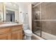 Bathroom features a vanity with a sink, toilet, shower with glass doors, and neutral tile at 11722 W Belmont Pl, Littleton, CO 80127