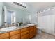 Bathroom with double sinks, granite countertops, and a shower with light-colored tile and a shower curtain at 11722 W Belmont Pl, Littleton, CO 80127