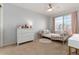 Cozy bedroom featuring light walls, a cream ceiling fan, and a well-lit vanity and white plush rug at 11722 W Belmont Pl, Littleton, CO 80127