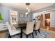 Elegant dining room with a modern chandelier, seating for six, and a view of the backyard at 11722 W Belmont Pl, Littleton, CO 80127