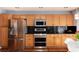 Renovated kitchen featuring stainless steel appliances, wood cabinetry, and a black countertop at 11722 W Belmont Pl, Littleton, CO 80127