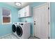 Bright laundry room features modern washer and dryer, storage cabinets, and stylish flooring at 11722 W Belmont Pl, Littleton, CO 80127