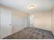 Neutral bedroom featuring carpet, a ceiling light, and white doors to the closet and bathroom at 1791 Quail St, Lakewood, CO 80215