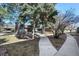Exterior view of home surrounded by mature trees, walkway, and landscaping at 1791 Quail St, Lakewood, CO 80215