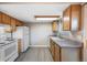 Updated kitchen with white appliances, wood cabinets, and new vinyl flooring at 1791 Quail St, Lakewood, CO 80215