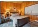 Cozy bedroom with wooden walls, plush rug, and a decorative mirror at 34788 Forest Estates Rd, Evergreen, CO 80439