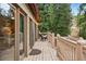 A wooden deck featuring a chair with a hammock, and glass doors against a background of trees at 34788 Forest Estates Rd, Evergreen, CO 80439