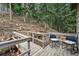 Outdoor deck with chairs overlooking a tranquil wooded area at 34788 Forest Estates Rd, Evergreen, CO 80439