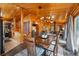 Cozy dining room featuring wood-paneled walls, modern light fixtures, and a view to the kitchen at 34788 Forest Estates Rd, Evergreen, CO 80439