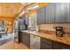Rustic kitchen with stainless steel appliances, granite counters, and wooden ceilings at 34788 Forest Estates Rd, Evergreen, CO 80439