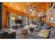 Comfortable living room with wood paneling, a wood-burning stove, and access to the deck at 34788 Forest Estates Rd, Evergreen, CO 80439