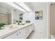 Bright bathroom features dual sinks, white cabinetry, and a large mirror at 8510 Union Cir, Arvada, CO 80005