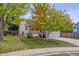 Traditional home with a well-manicured front yard, inviting porch, and attached garage at 8510 Union Cir, Arvada, CO 80005