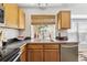 Modern kitchen sink area with stainless steel appliances, wood cabinets, and a view of the outdoors through the window at 8510 Union Cir, Arvada, CO 80005