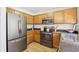 Bright kitchen with stainless steel appliances, wooden cabinets, and hardwood floors offer a modern and functional space at 8510 Union Cir, Arvada, CO 80005