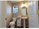 Charming half bathroom features a pedestal sink, new light fixture and ample room at 9703 Ogden Ct, Thornton, CO 80229