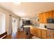 Bright kitchen with wood cabinets and stainless appliances connects to dining and living spaces at 9703 Ogden Ct, Thornton, CO 80229