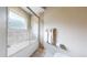 Bright bathroom featuring neutral tiles, a frosted window, and a shower-over-tub with glass doors at 11194 W Yucca, Littleton, CO 80125