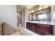 Dual sink bathroom vanity with white counters and dark wood cabinets, plus lots of natural light at 11194 W Yucca, Littleton, CO 80125