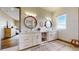 Elegant bathroom with double vanities, round mirrors, white cabinets, and ample lighting at 11194 W Yucca, Littleton, CO 80125